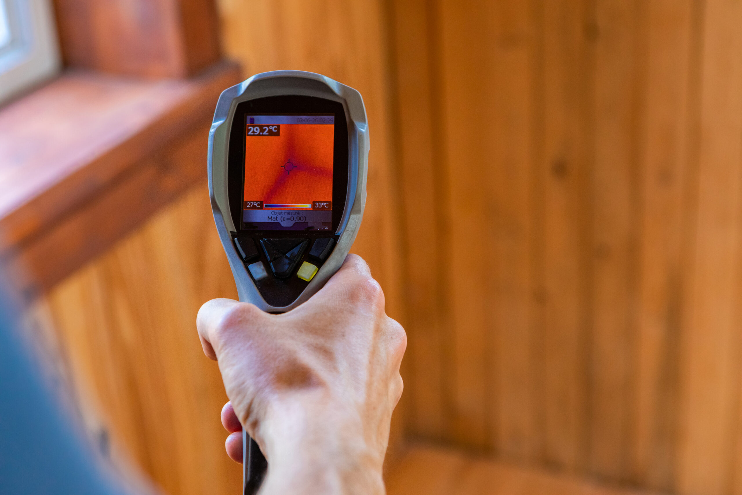 A close up view on the lcd screen of a hand held infrared thermal imagery camera in the hand of a home inspector during environmental quality assessment.